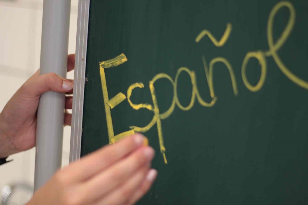 Teacher writing Spanish on a blackboard