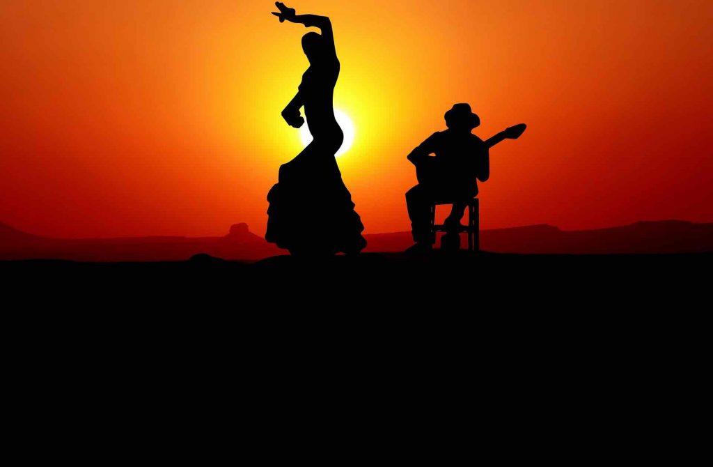 Flamenco dancer and guitar player in front of sunset
